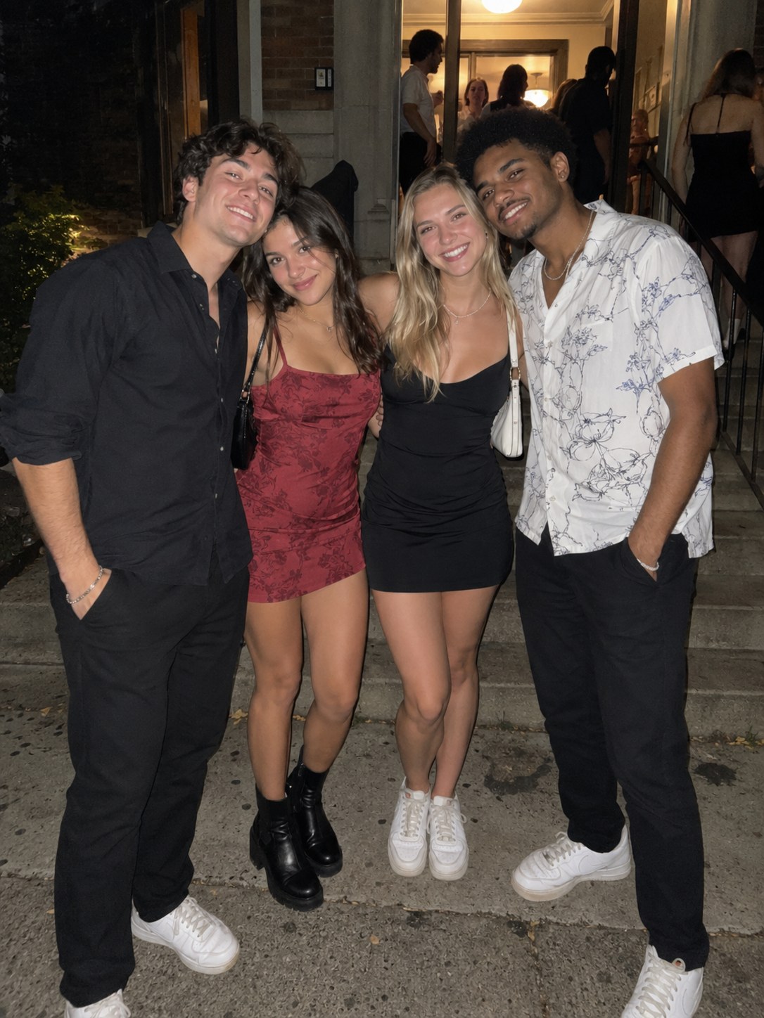 Four friends on a stoop at night, straight off the phone