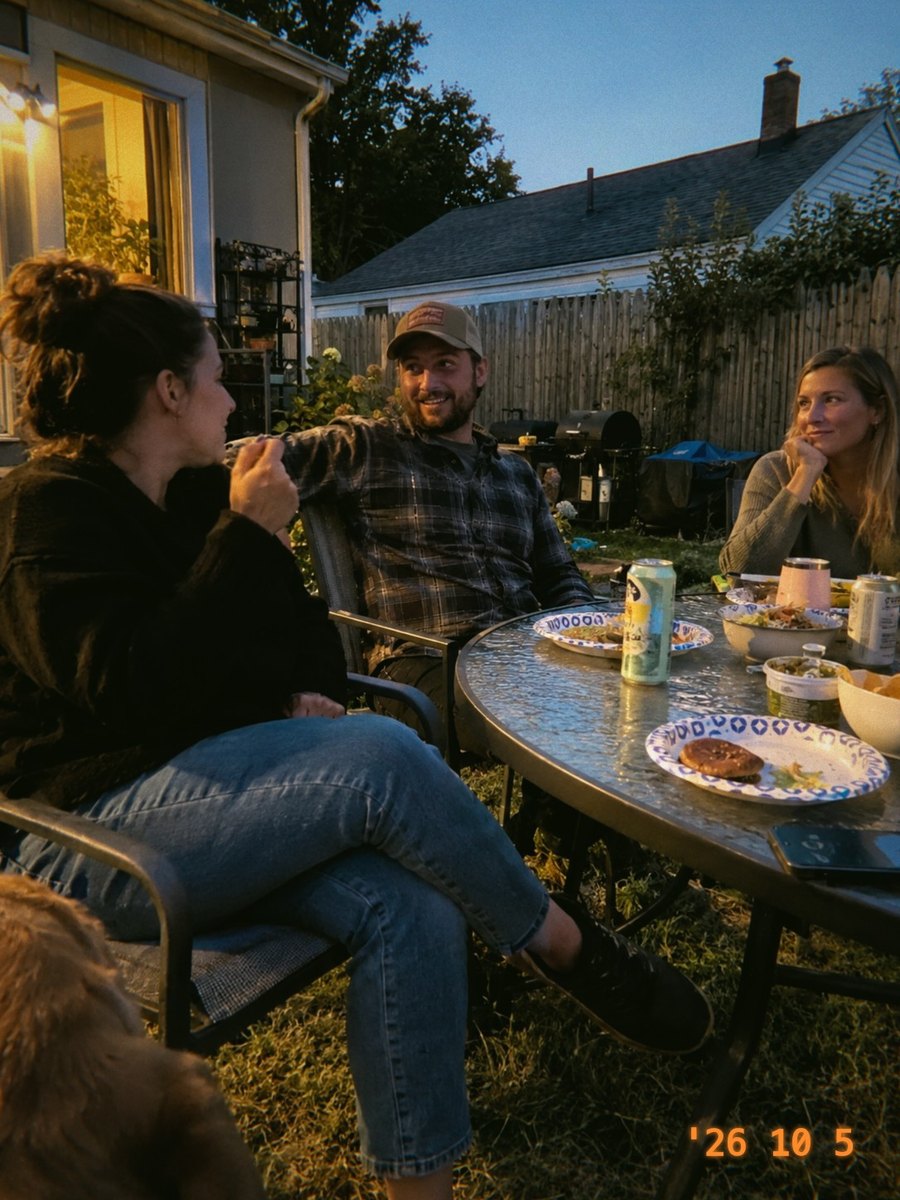 Three friends at a patio table at dusk, in Jamm 400