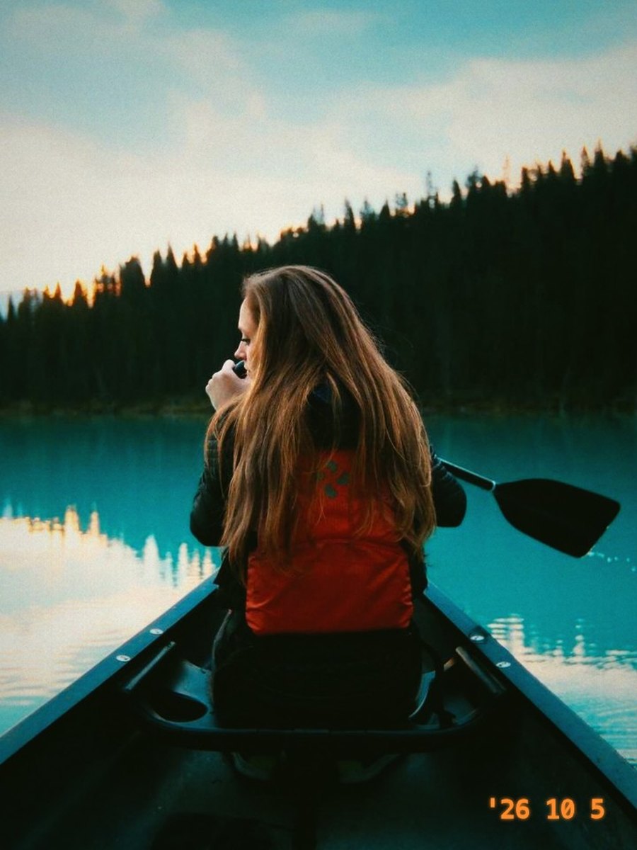 A friend paddling a canoe on a still lake, in Jamm 400